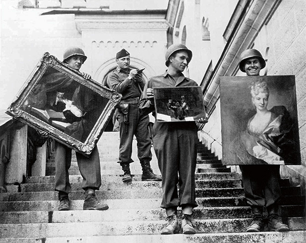 Associated Press, “Monuments Man” James Rorimer, with notepad, supervises U.S. soldiers as they carry paintings down the steps of the castle in Neuschwanstein, Germany, in May 1945.