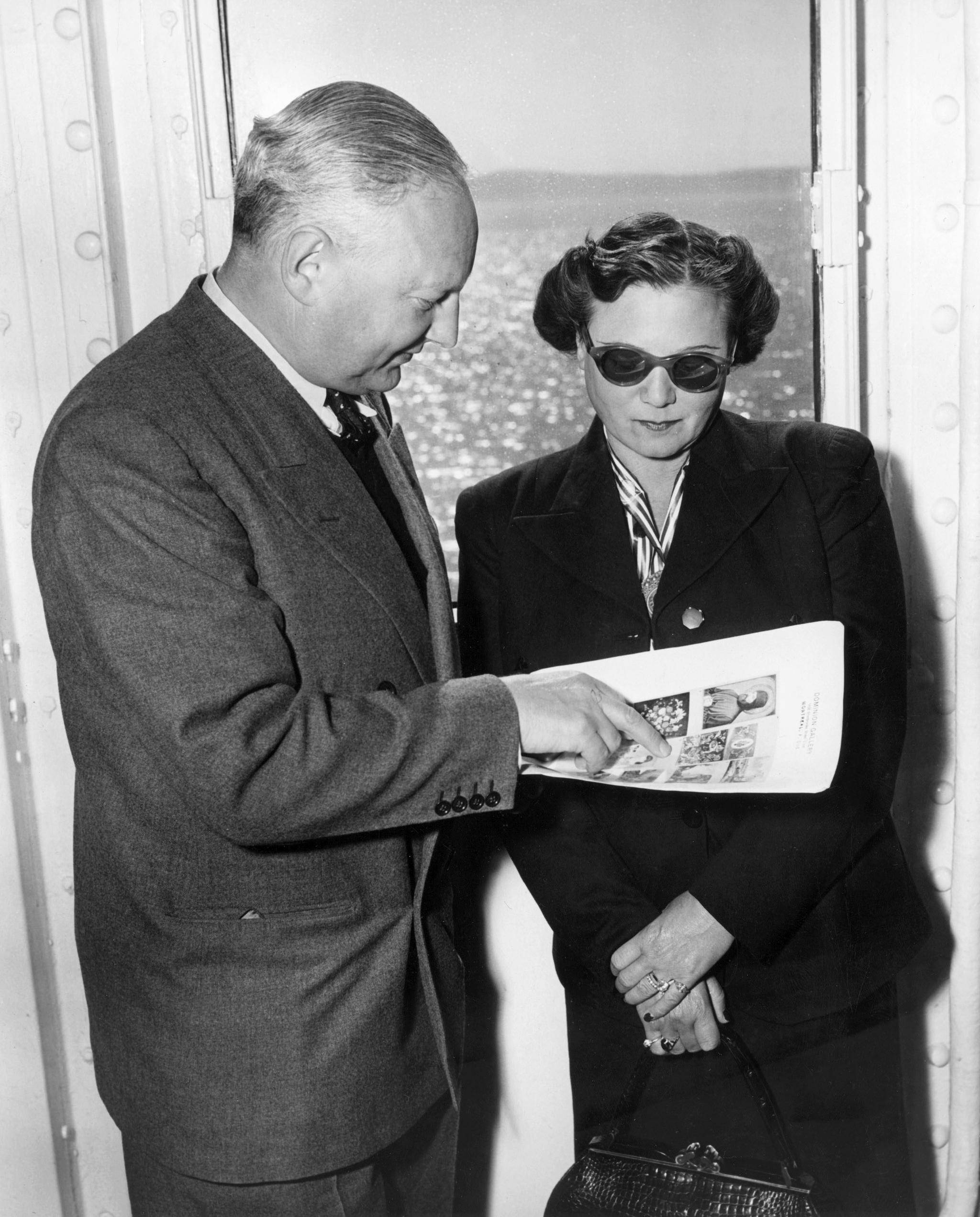 Max Stern and his wife, Iris, are on a ship looking at an advertisement showing art works that they were pursuing from the Stern collection lost during the Nazi period, c. 1952. Courtesy of CONCORDIA UNIVERSITY VIA AP